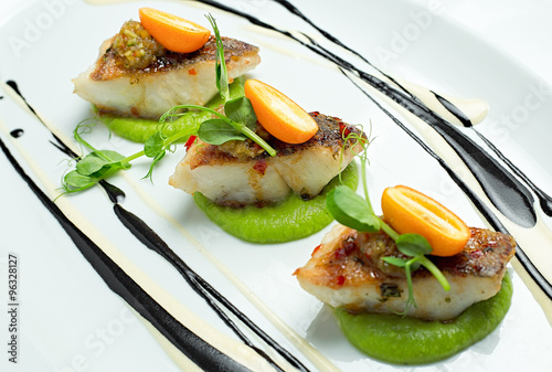 Fototapeta Naklejka Na Ścianę i Meble -  Delicious fish served on white dish, decorated with salad and sauce