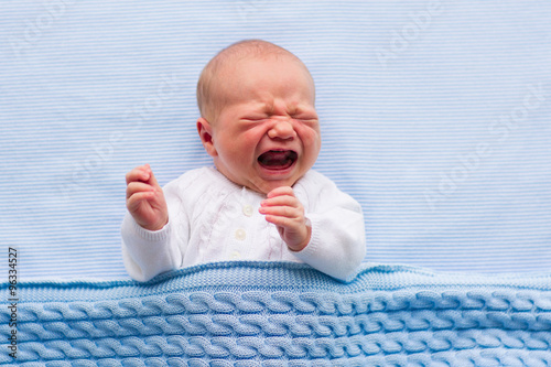 Foto Newborn baby boy on a blue blanket