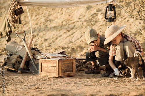 Children archaeologists take notes in a notebook on the excavations conducted