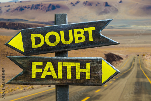 Doubt - Faith signpost in a desert road on background