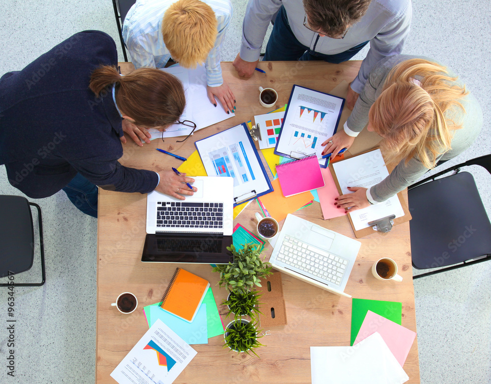 Image of business partners discussing documents and ideas at meeting Image of business partners discussing documents and ideas at meeting