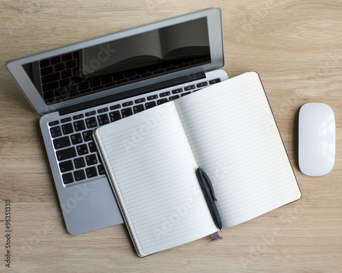 Laptop and Notepad with pen - top view on wooden table with space for your text.