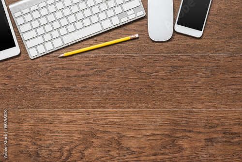 office wooden table with yellow pencil, tablet, keyboard, mouse