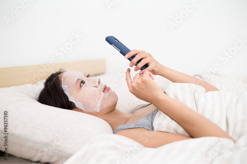 Young Asian woman use of the mobile phone and use of the facial