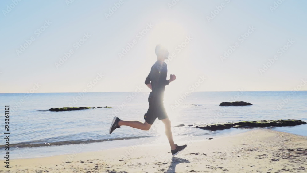 young man running on the beach slow motion
