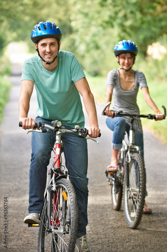 Young Couple Cycling Along Country Road © highwaystarz
