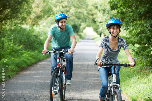 Young Couple Cycling Along Country Lane