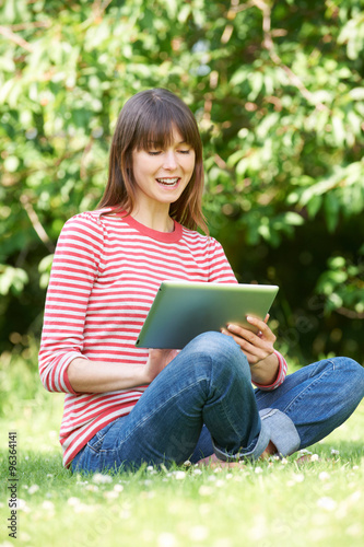 Attractive Young Woman Using Digital Tablet In Park