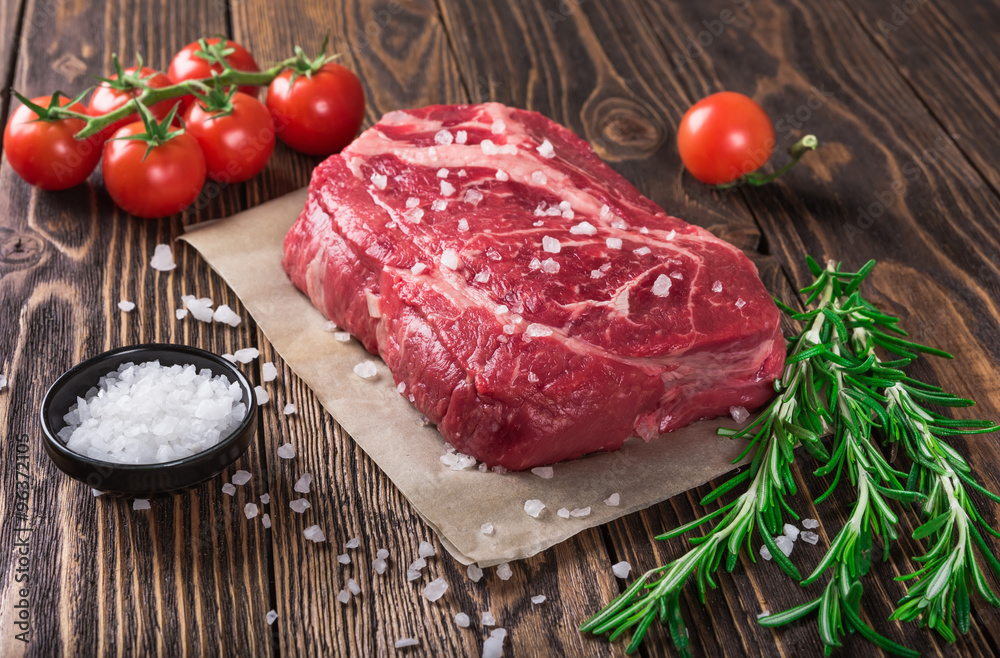 Raw marbled meat steak Ribeye on dark wooden background