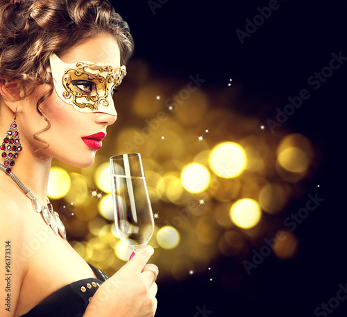 Sexy model woman with glass of champagne wearing venetian masquerade mask