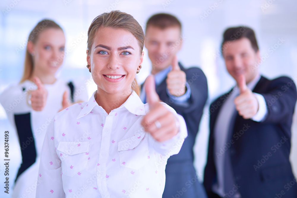 Happy business team showing thumbs up in office Happy business team showing thumbs up in office