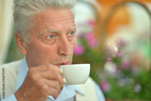 Elderly man with cup of coffee