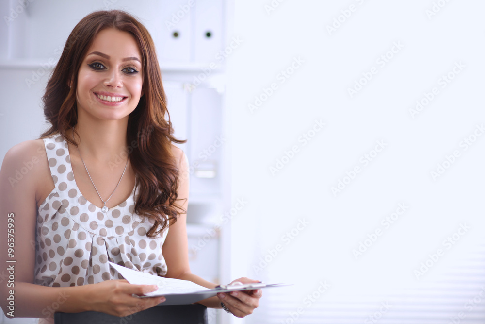 Young happy businesswoman in office holding a folder Young happy businesswoman in office holding a folder