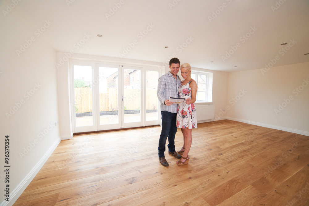Young Couple Looking At Property Details For New Home