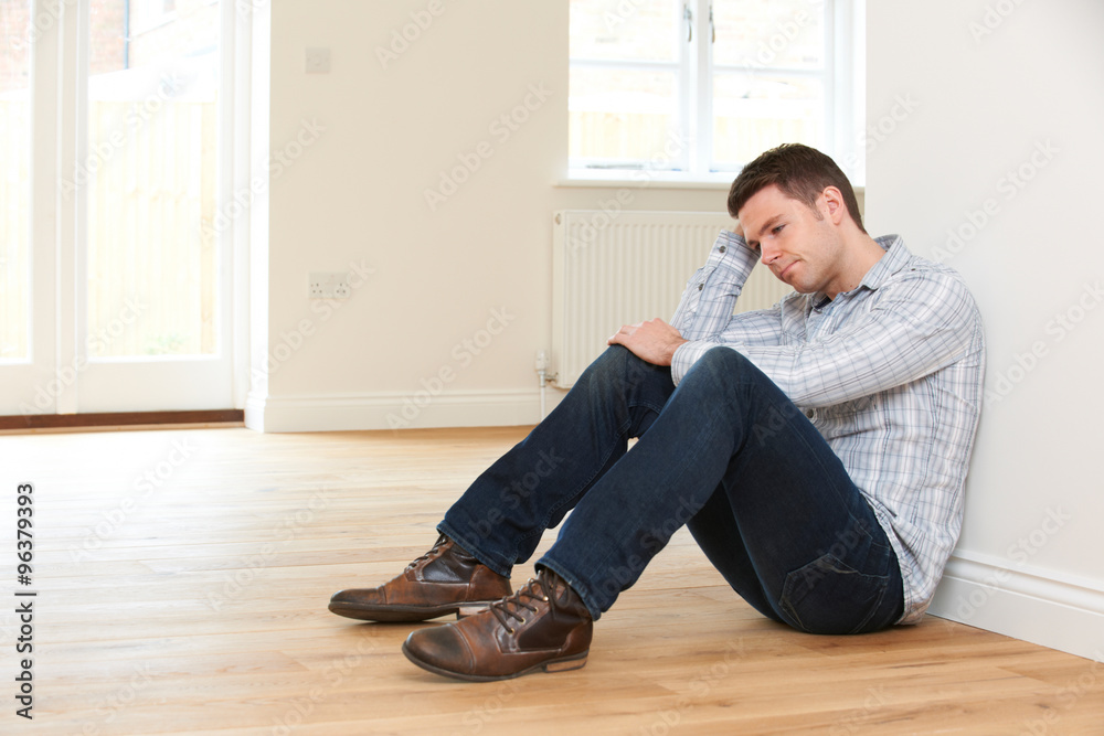 Depressed Man Sitting In Empty Room Of Repossessed House Depressed Man Sitting In Empty Room Of Repossessed House