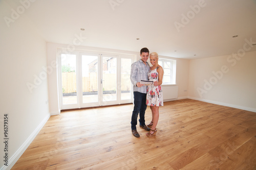 Young Couple Looking At Property Details For New Home