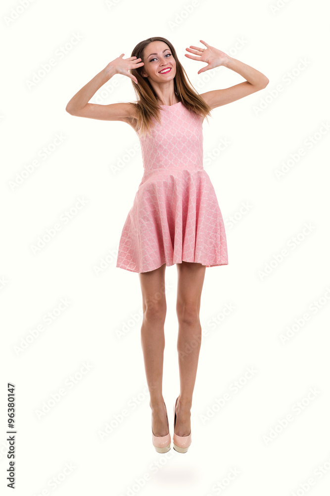 Full length of sensual woman in short dress jumping against isolated white