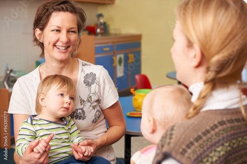 Tableau sur toile Two Mothers With Chidren Chatting At Playgroup