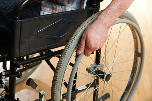 Close Up Of Man's Hands Pushing Wheelchair