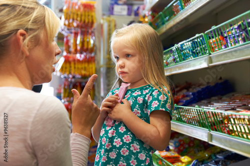 Girl Having Arguement With Mother At Candy Counter In Supermarke photo