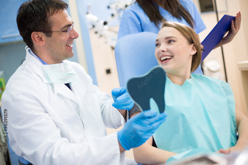 Satisfied girl and dentist in dental ambulance smiling Satisfied girl and dentist in dental ambulance smiling