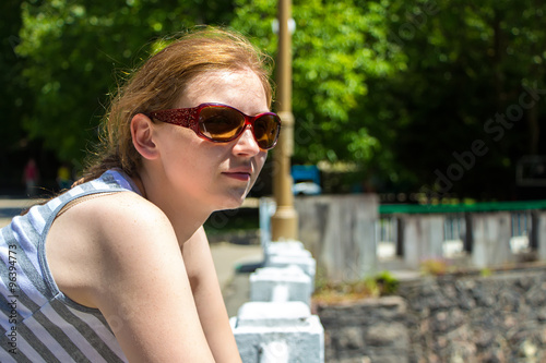 Young woman with sunglasses looking away photo