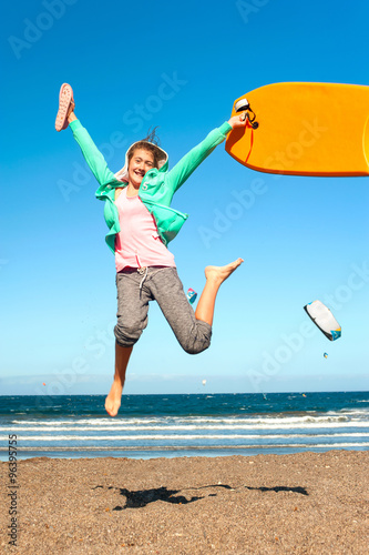 Young cheerful jumping teenage girl excitement on Atlantic ocean