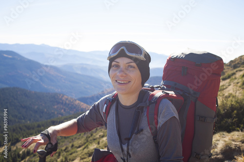 Girl with a backpack climbs the hill.