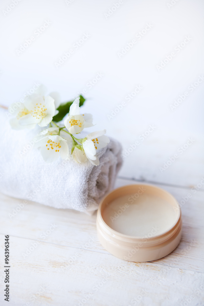 beauty treatment , jasmin flowers and cosmetics   on white wooden table