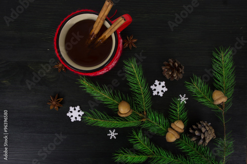 Hot tea on wooden table near pine branches