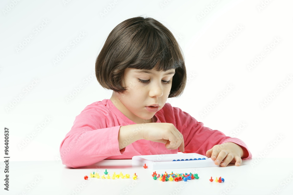 little girl is playing with Mushroom Nails pegboard on a white background, dressing a pink shirt little girl is playing with Mushroom Nails pegboard on a white background, dressing a pink shirt