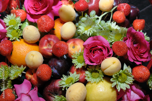 Fruits and flowers. Background with fruit and flowers. The fruit harvest. The texture of the fruit. The flowery background. Assorted fruit. Fruit basket. Festive fruits set.