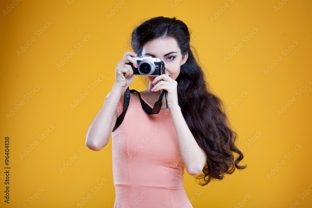 Obraz premium Fashion asian young girl photographer with camera, portrait on yellow background