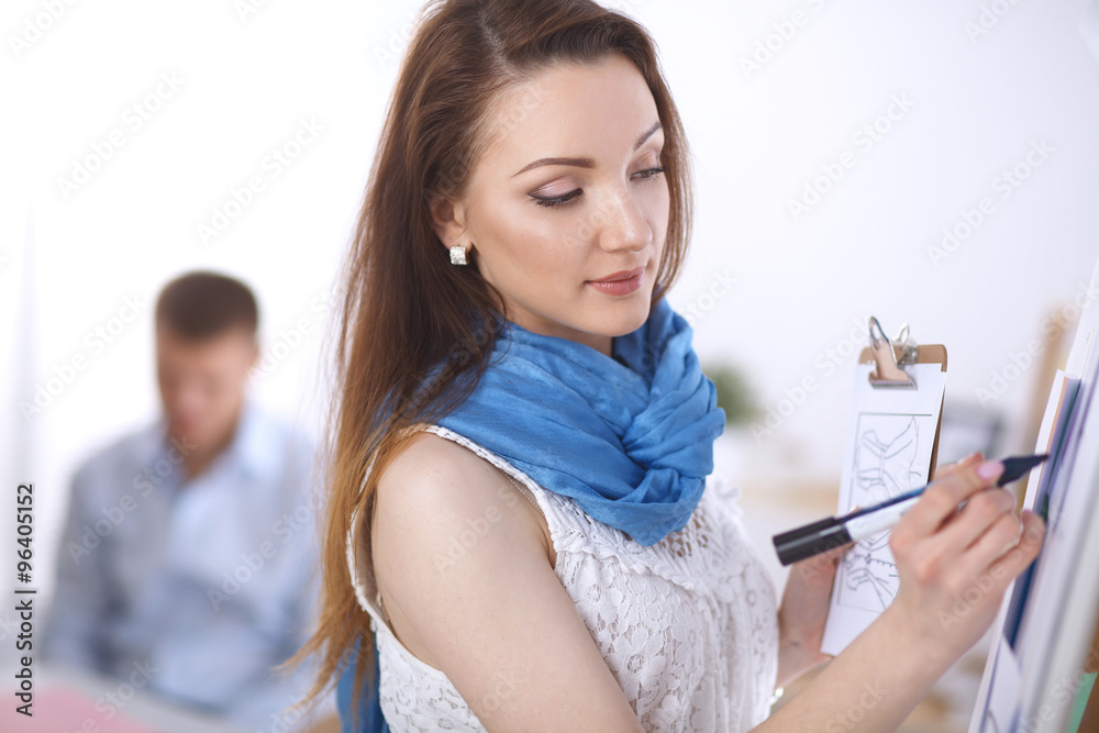 Young woman drawing on wihteboard with white copyspace Young woman drawing on wihteboard with white copyspace