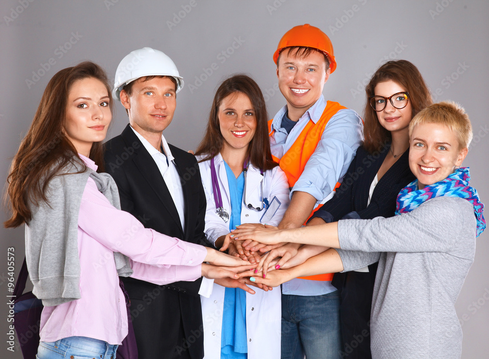 Portrait of people with various occupations putting their hands on top of each other