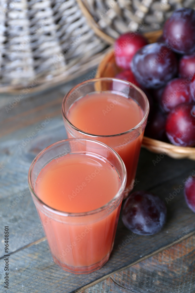 Delicious plum juice with fruits on wooden table close up Delicious plum juice with fruits on wooden table close up
