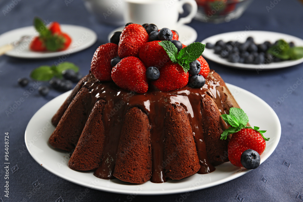 Delicious chocolate cake with strawberries in plate on table, closeup Delicious chocolate cake with strawberries in plate on table, closeup