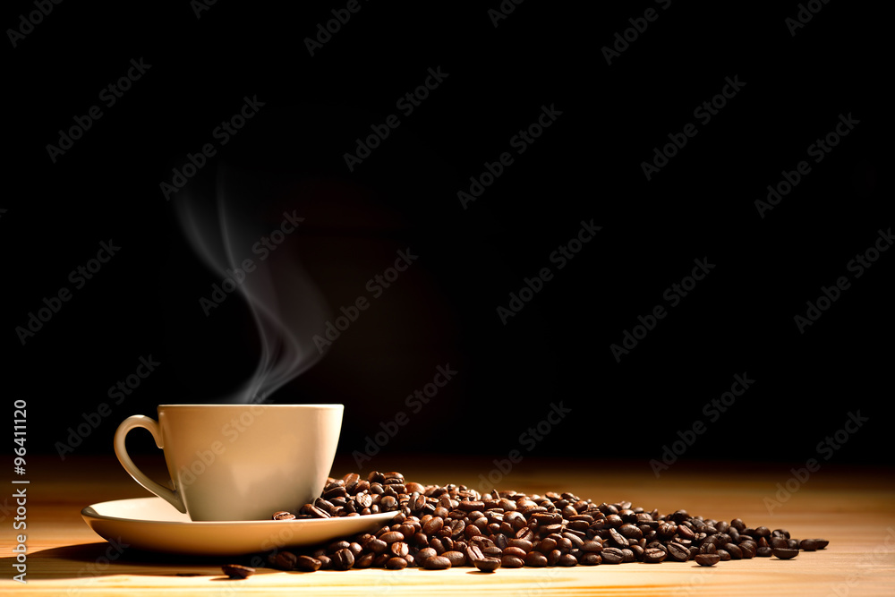 Fototapeta Filiżanka kawy z dymnymi i kawowymi fasolami na starym drewnianym tle