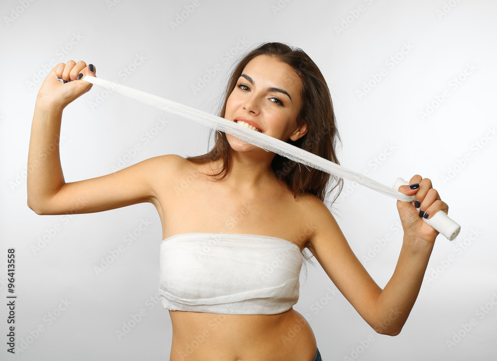 Young beautiful woman tearing gauze with her teeth, isolated on white Young beautiful woman tearing gauze with her teeth, isolated on white