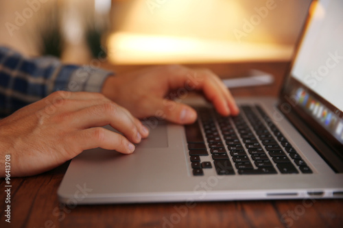 Young man using his laptop, close up