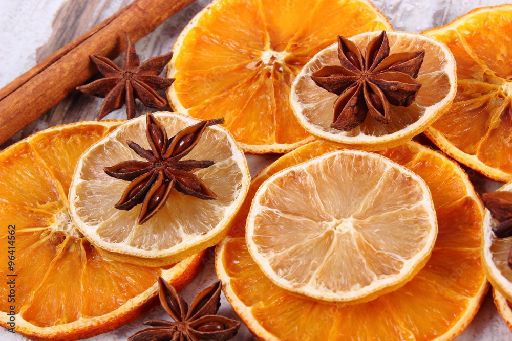 Slices of dried lemon, orange and spices on old wooden background Slices of dried lemon, orange and spices on old wooden background