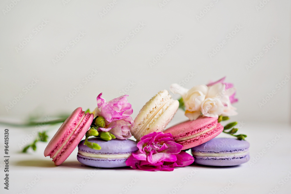 Freesia with macaroons on a table on a white background