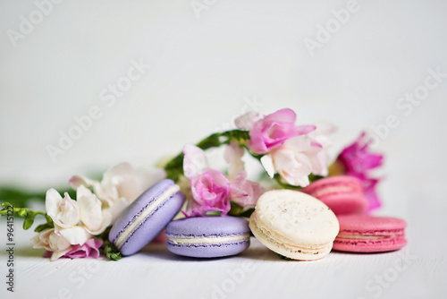 Freesia with macaroons on a table on a white background