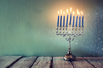 abstract retro filtered low key image of jewish holiday Hanukkah with menorah (traditional Candelabra). with glitter overlay
