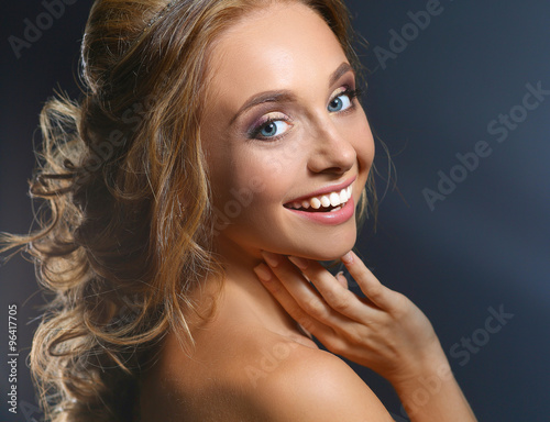 Beautiful woman with curly long hair on dark background