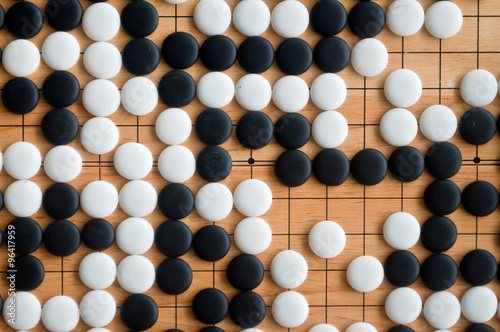 Go pieces on wooden board