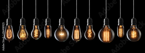 Fotografiet Set of vintage glowing light bulbs on black background