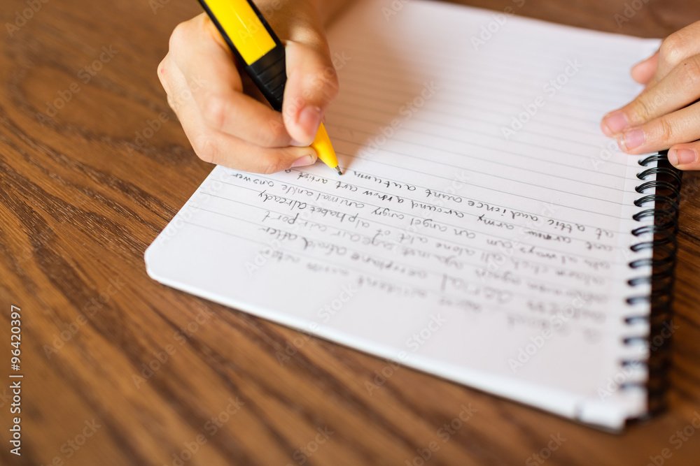 Girl writing by hand on notepad Girl writing by hand on notepad