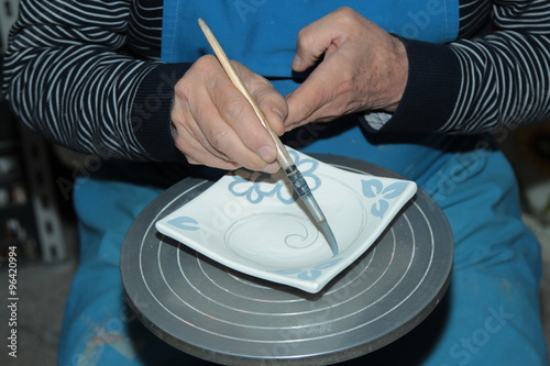 Mani al lavoro, dipingendo la ceramica 