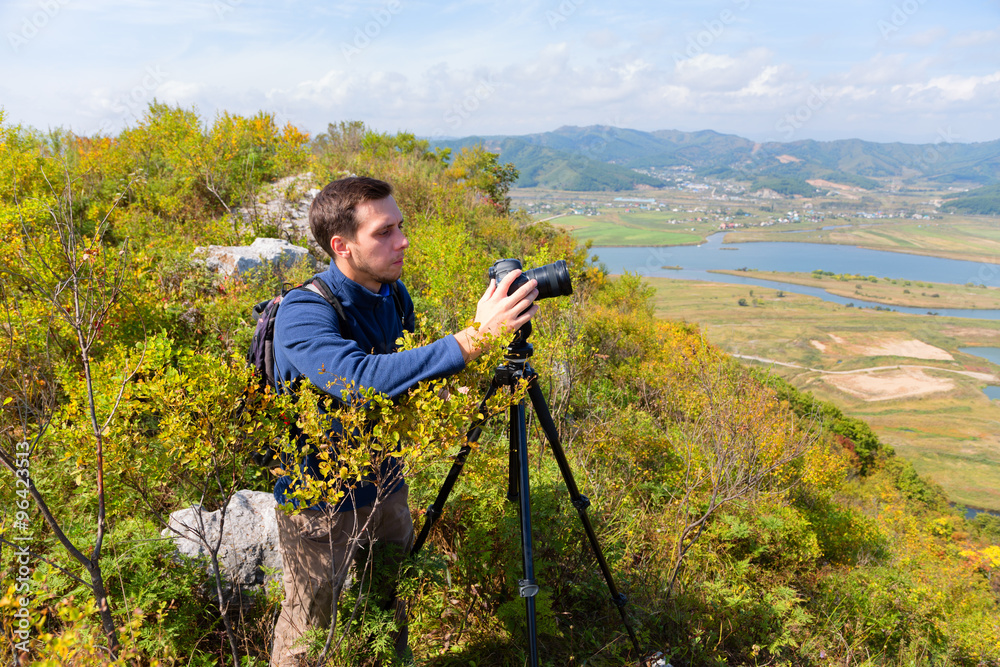 Photographer on the camera shoots landscape